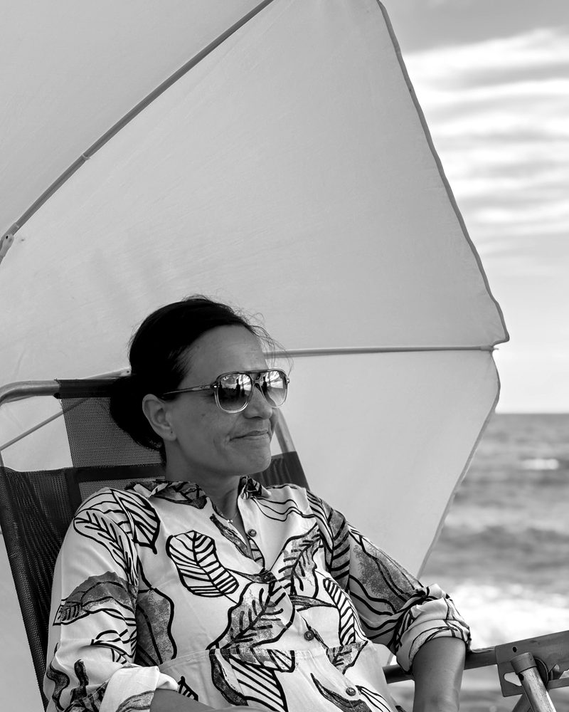 Ine en la playa, bajo una sombrilla